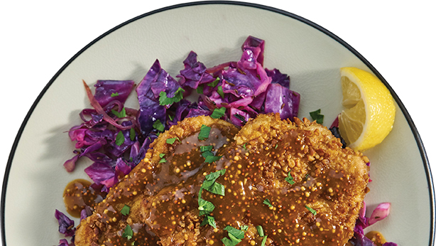 Schnitzel over red cabbage with lemon wedge