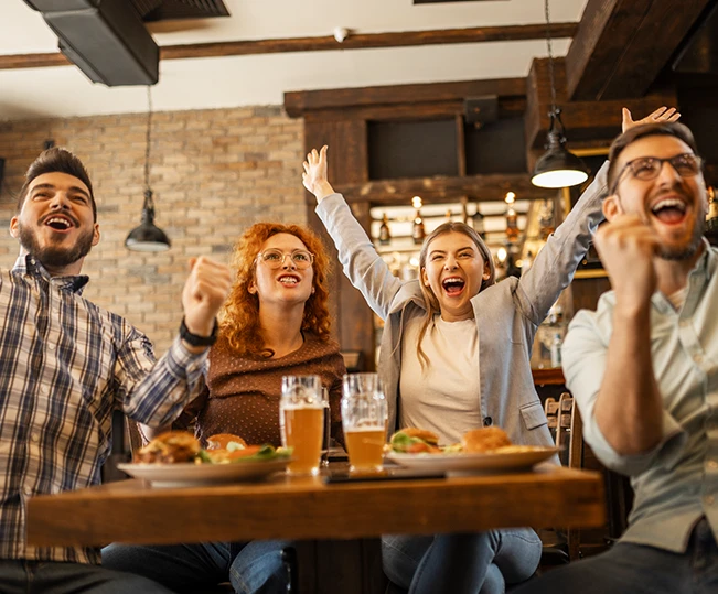 Group of friends enjoying appetizer drinking and eating in a bar - Close-up of hands of young people holding colorful cocktails in the happy hour time